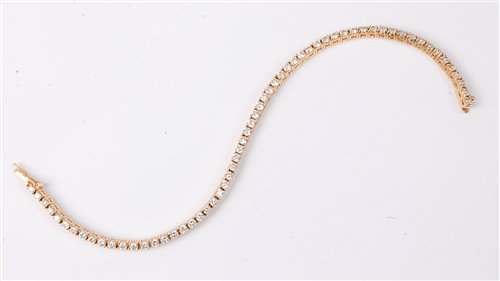 Lot 1194 - An 18ct diamond line bracelet, set with round...
