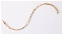 Lot 1194 - An 18ct diamond line bracelet, set with round...