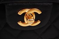 Lot 176 - A Coco Chanel black leather quilted flat-bag,...