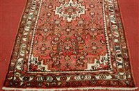 Lot 1563 - *A Persian woollen red ground rug, having a...