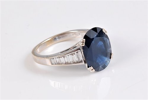 Lot 1159 - An 18ct sapphire and diamond ring, the oval...