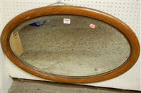 Lot 1165 - A 1920s oak framed bevelled oval wall mirror,...