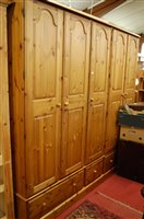 Lot 1199 - A large modern pine five door wardrobe, having...