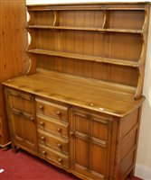 Lot 1221 - A contemporary Ercol mid-elm dresser, having...