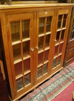 Lot 1291 - A modern pine ledgeback three door glazed...