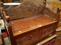Lot 1298 - An Eastern stained hardwood two-seater hinged...
