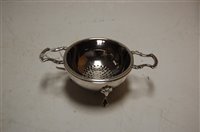 Lot 355 - A modern silver twin handled tea strainer on...