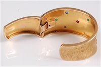 Lot 1190 - An 18ct gemset hinged cuff bracelet, the satin...