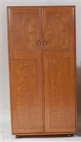 Lot 453 - An Ercol blond elm double door wardrobe,...