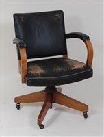 Lot 373 - An Art Deco light oak swivel desk elbow chair,...