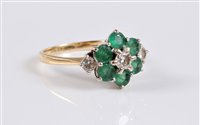 Lot 2703 - An 18ct emerald and diamond cluster ring, the...
