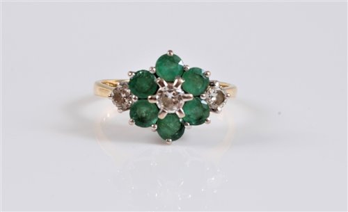 Lot 2703 - An 18ct emerald and diamond cluster ring, the...