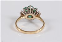Lot 1191 - An 18ct emerald and diamond cluster ring, the...