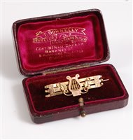 Lot 316 - A 9ct gold bar brooch with a lyre and three...