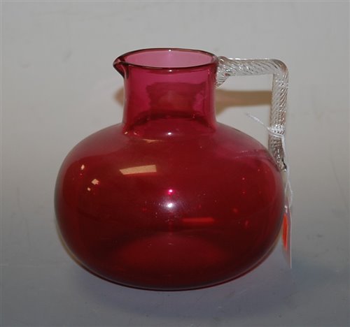 Lot 136 - A Victorian cranberry glass water jug having a...