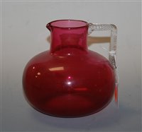 Lot 136 - A Victorian cranberry glass water jug having a...