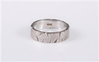 Lot 401 - An 18ct white gold wedding band, the textured...