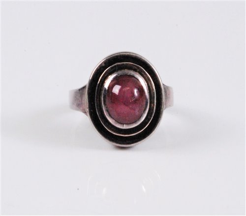 Lot 2577 - A star ruby ring, the oval star ruby cabochon,...