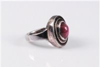 Lot 2577 - A star ruby ring, the oval star ruby cabochon,...