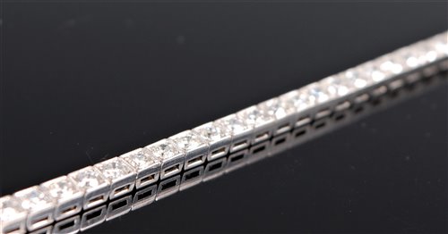 Lot 1245 - A diamond line bracelet, the round brilliant...