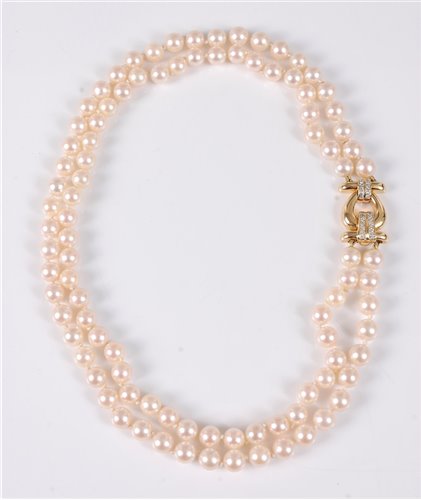 Lot 1211 - A two strand cultured pearl necklace with 18ct...