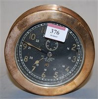 Lot 376 - A brass cased bulkhead clock, having black...