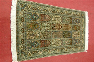 Lot 1559 - A Persian woven silk rug, having five rows of...