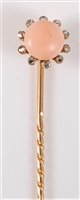 Lot 2504 - A coral and diamond stick pin: the round coral...