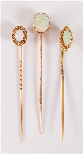 Lot 2510 - Three opal stick pins: to include a marquise...