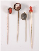 Lot 2530 - Four cameo stick pins: a round painted...