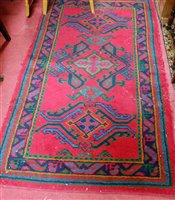 Lot 1196 - A Turkish woollen red ground rug, 98x174cm,...