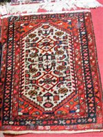 Lot 1203 - A Persian style machine woven red ground rug,...