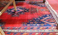 Lot 1205 - A Caucasian woollen red ground rug having a...