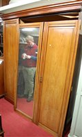 Lot 1136 - An Edwardian walnut triple wardrobe, the...