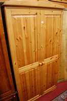 Lot 1219 - A modern pine effect double door wardrobe,...