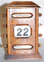 Lot 535 - An Edwardian oak cased perpetual desk calendar,...