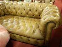 Lot 1415 - A faded green leather upholstered buttoned two...