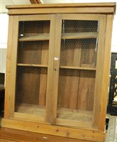 Lot 1435 - A pine double door food cupboard having wire...