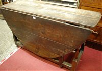 Lot 1483 - An antique planked oak dropleaf dining table,...