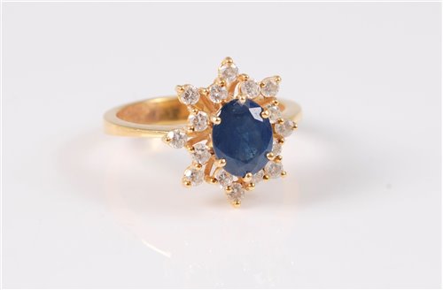 Lot 1239 - An 18ct sapphire and diamond cluster ring, the...