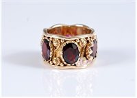 Lot 1295 - A garnet eternity ring, the oval faceted...