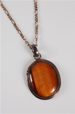 Lot 326 - A tigers eye pendant, the oval cabochon,...