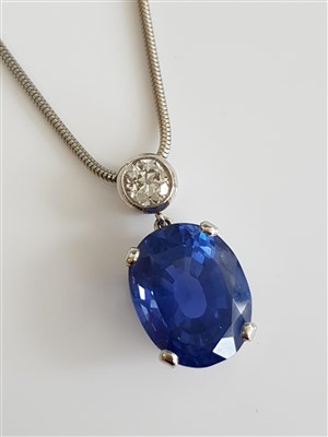 Lot 1254 - A sapphire and diamond pendant, the oval mixed...