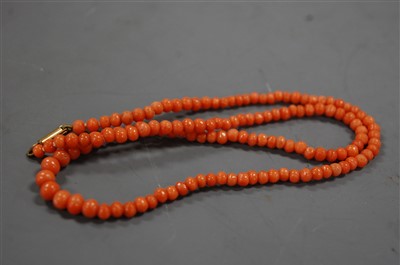 Lot 1301 - A coral bead necklace and a coral bangle, the...