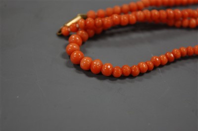 Lot 381 - A coral bead necklace and a coral bangle, the...