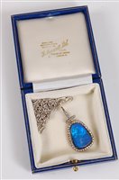 Lot 1255 - A black opal and diamond pendant, the rounded...