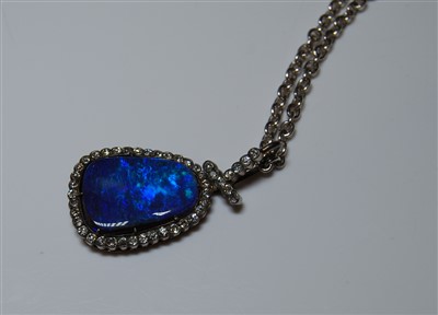Lot 1255 - A black opal and diamond pendant, the rounded...