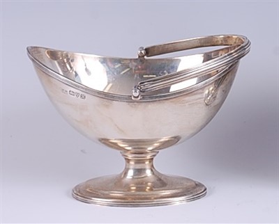 Lot 1206 - A George V silver bonbon basket, having reeded...