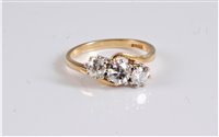 Lot 1242 - An 18ct three stone crossover diamond ring,...