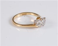 Lot 1242 - An 18ct three stone crossover diamond ring,...